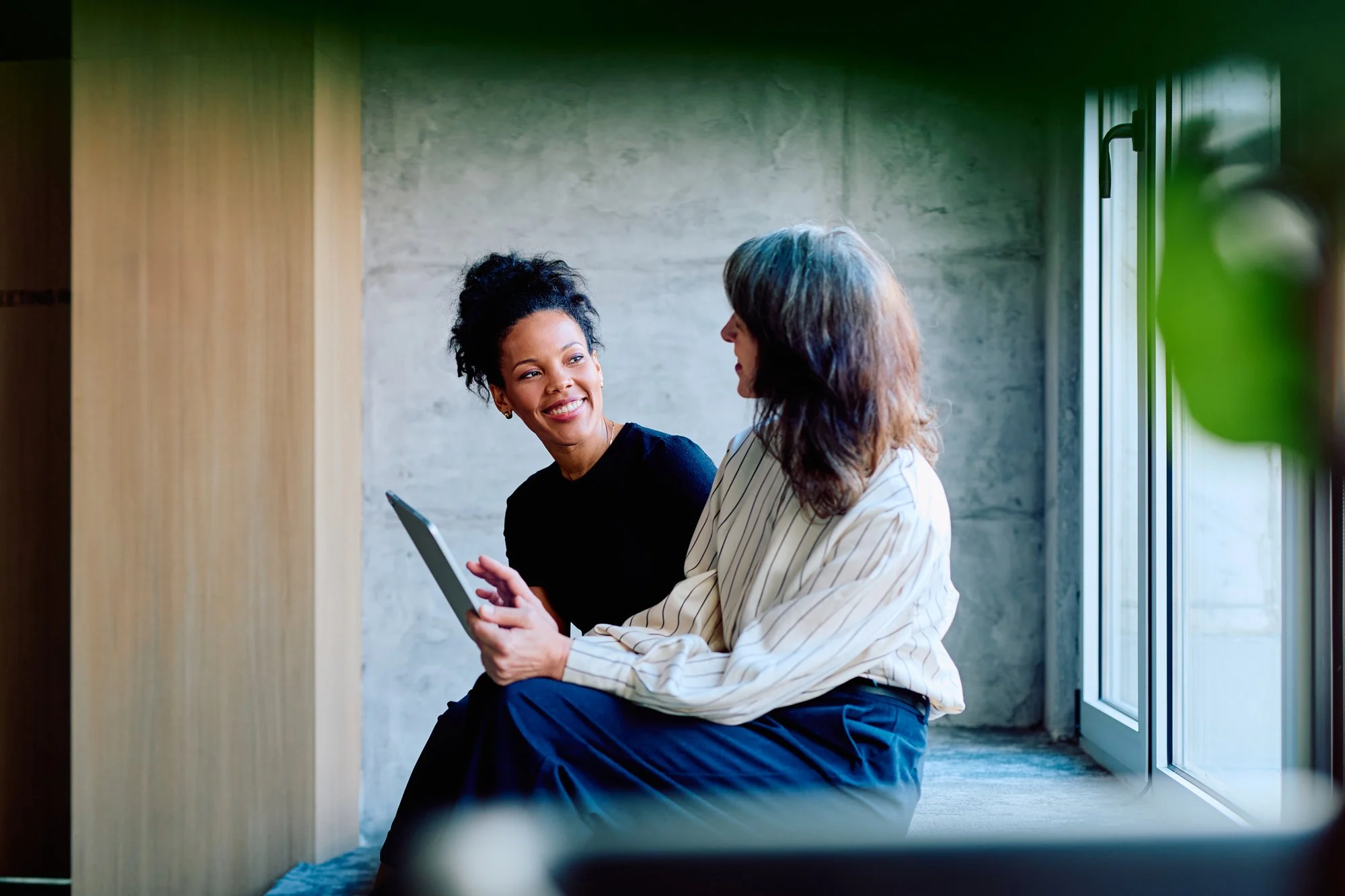 Twee collega's in gesprek met een tablet
